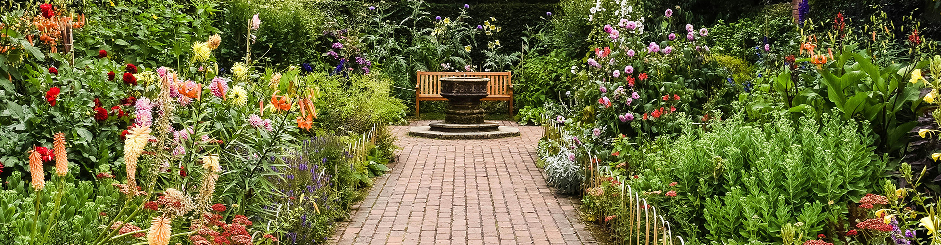 Parkweg mit einer Bank und Blumen